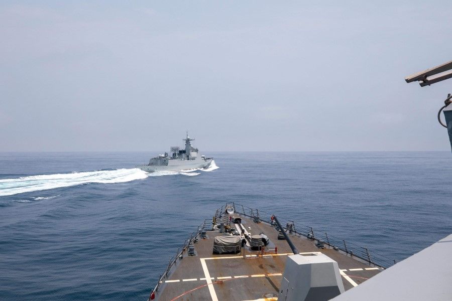 This handout photo taken on 3 June 2023 by the US Navy shows the Arleigh Burke-class guided-missile destroyer USS Chung-Hoon observing the Chinese PLA Navy vessel Luyang III (top) while on a transit through the Taiwan Strait with the Royal Canadian Navy's HMCS Montreal. (Andre T. Richard/US Navy/AFP)