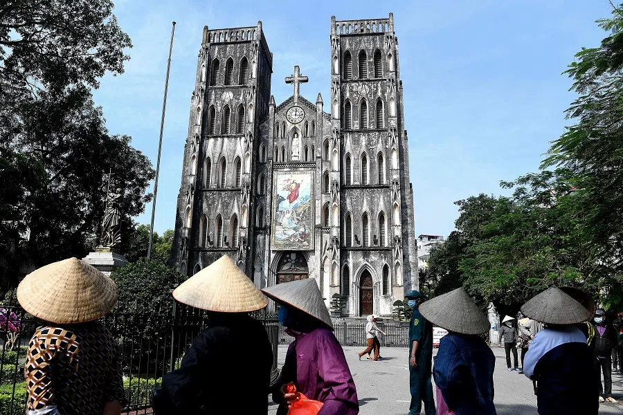 Residents wearing face masks stand in a queue for free rice at the St. Joseph's cathedral in the old quarters of Hanoi on 27 April 2020. (Nhac Nguyen/AFP)