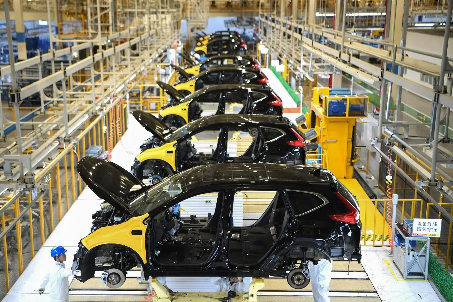 This photo taken on 27 November 2019 shows employees working on an assembly line at the third auto plant of Dongfeng Honda in Wuhan. (STR/AFP)