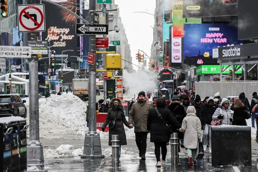 Pedestrians walk along a snow covered street as a major winter storm spreads across a large swath of the US, in New York City, US, 26 January 2026. (Jeenah Moon/Reuters)