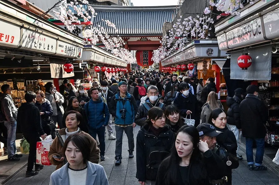 People walk along the main shopping street at Sensoji Temple in the popular tourist destination of Asakusa in central Tokyo on 21 February 2025.