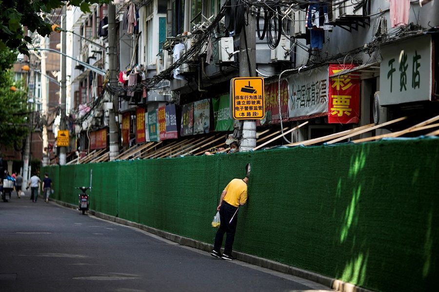 A man looks in through a gap in a barrier in a residential area, after the lockdown placed to curb the Covid-19 outbreak was lifted, in Shanghai, China, 7 June 2022. (Aly Song/File Photo/Reuters)