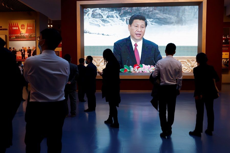 Visitors stand near a screen showing an image of Chinese President Xi Jinping at the Museum of the Communist Party of China in Beijing, China, 11 November 2021. (Carlos Garcia Rawlins/Reuters)