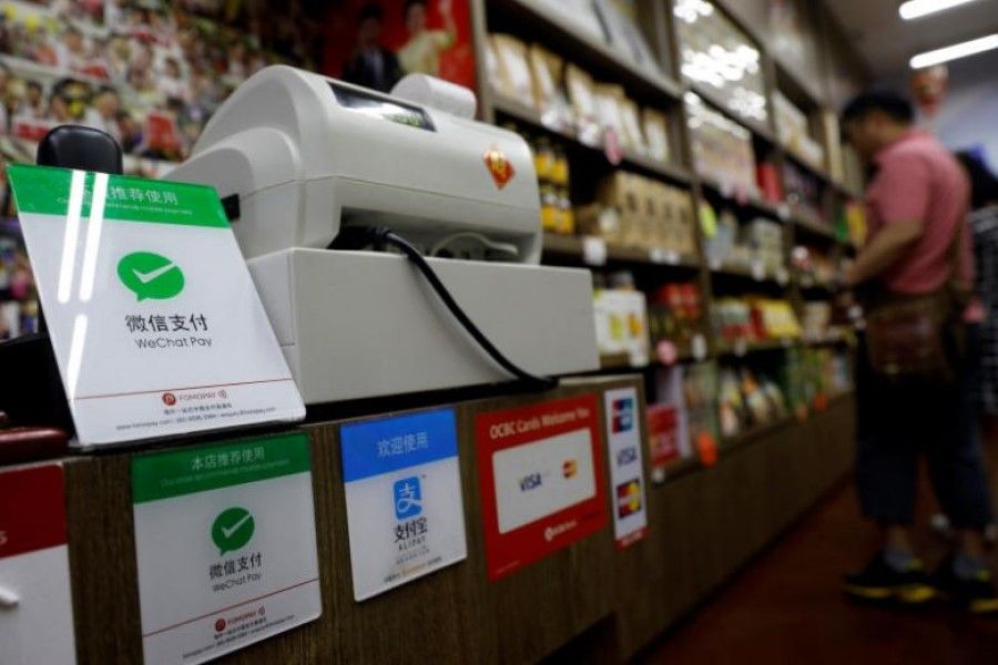 A WeChat Pay sign (left) on display at a shop in Singapore, on 22 May 2018. (Handout via Reuters)