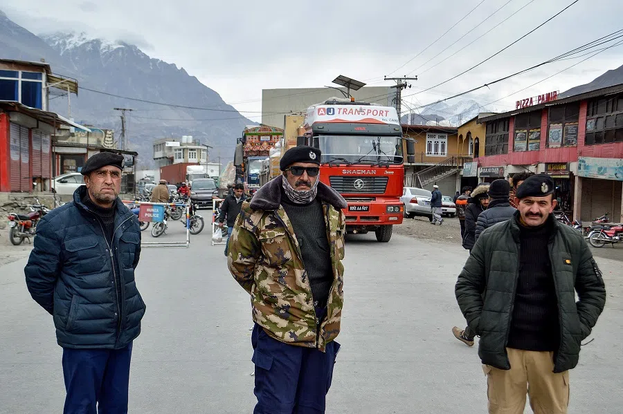 Police personnel stand guard as trucks lie stranded along the Karakoram Highway, blocked by residents during a sit-in protest against power outages at Hunza Valley, in Pakistan’s mountainous Gilgit-Baltistan region on 6 January 2025. (AFP)