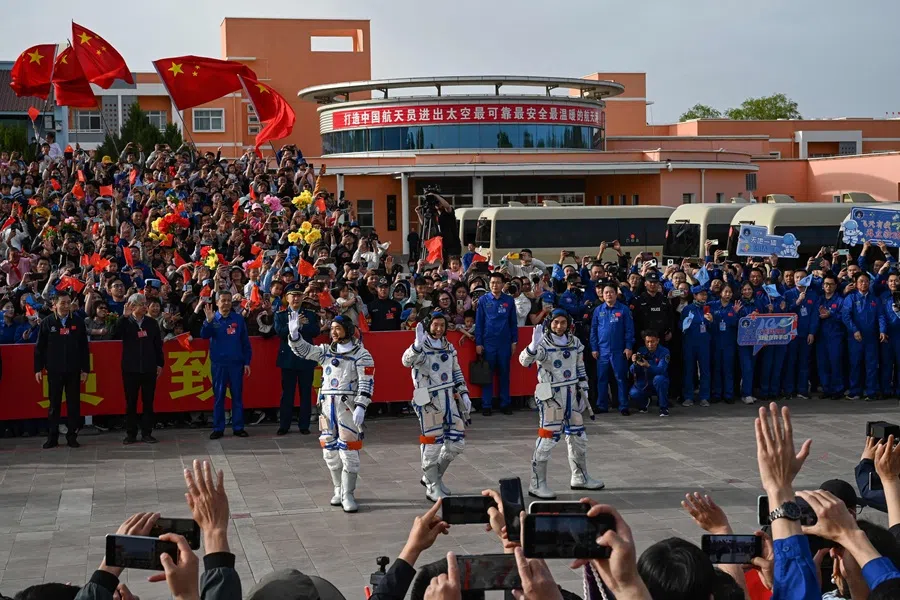 Astronauts for China’s Shenzhou-18 space mission (left to right) Li Guangsu, Li Cong and Ye Guangfu wave during a departure ceremony before boarding a bus to take them to the Shenzhou-18 spacecraft at the Jiuquan Satellite Launch Center in the Gobi desert in northwest China on 25 April 2024. (Greg Baker/AFP)