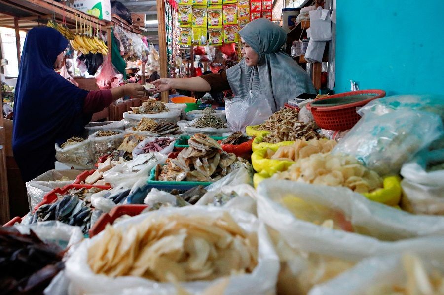 A vendor serves a customer at a traditional market in Jakarta, Indonesia, 2 January 2023. (Ajeng Dinar Ulfiana/Reuters)