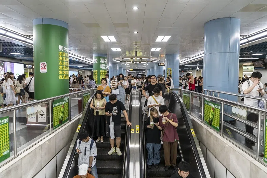 Commuters ride escalators at a metro station in Guangzhou, China, 30 July 2024. (Qilai Shen/Bloomberg)
