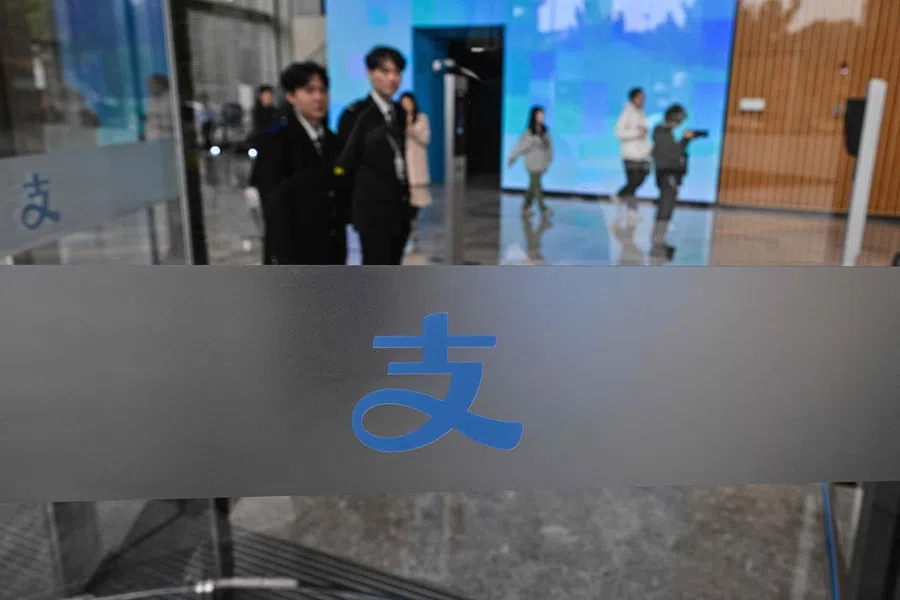 People walk in the headquarters of Chinese digital payments platform Alipay in the Pudong district in Shanghai on 12 November 2025. (Hector Retamal/AFP)