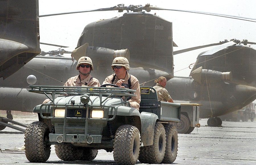 In this file photo taken on 2 July 2002, US soldiers drive past Chinook helicopters at Bagram air base. (Jewel Samad/AFP)