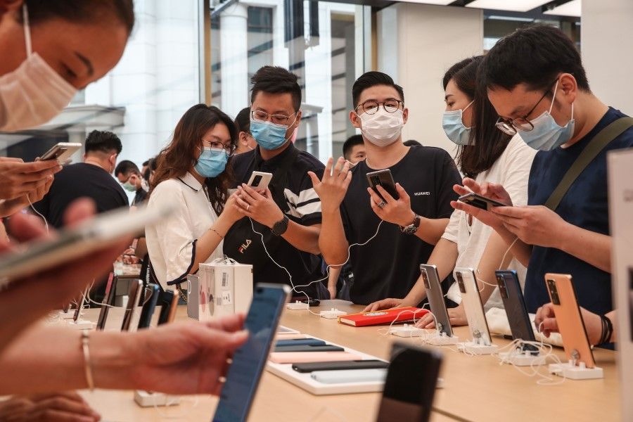 Customers look at Huawei smartphones at a newly-opened Huawei global flagship store in Shanghai, 24 June 2020. (STR/AFP)