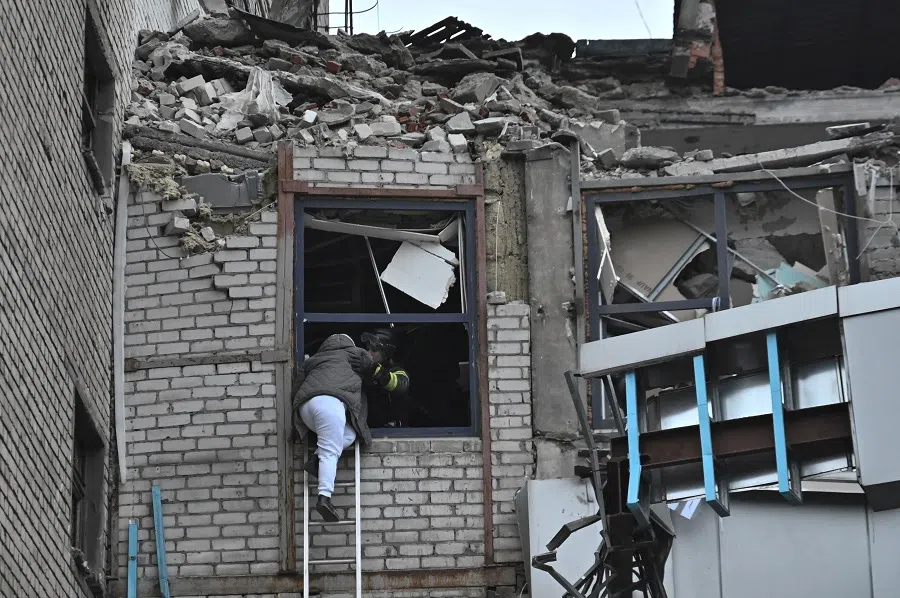 A rescuer evacuates a woman from a building heavily damaged by a Russian missile strike, amid Russia’s attack on Ukraine, in Zaporizhzhia, Ukraine, on 10 December 2024.