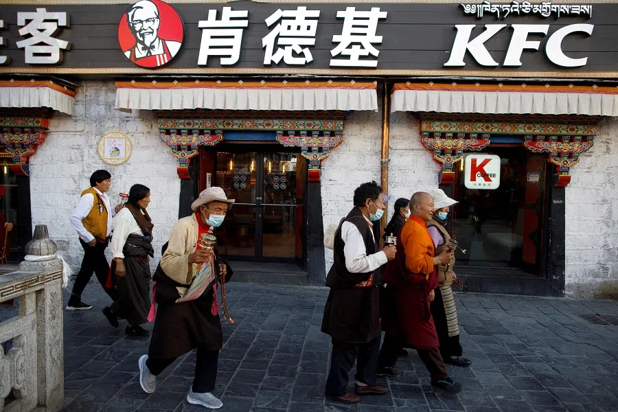 Tibetans walk past a KFC fast food restaurant as they perform a pilgrimage around the Jokhang Temple in Lhasa, during a government-organised tour of the Tibet Autonomous Region to showcase poverty alleviation in China, 15 October 2020. (Thomas Peter/Reuters)