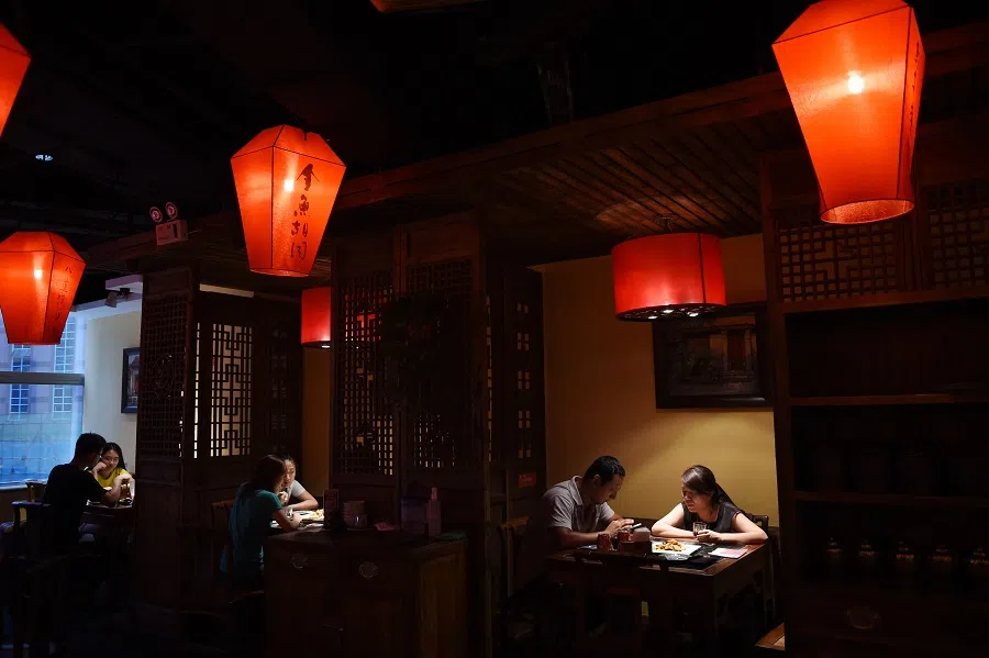 This file photo taken on 15 July 2015 shows diners eating lunch at a restaurant in Beijing. (Greg Baker/AFP)