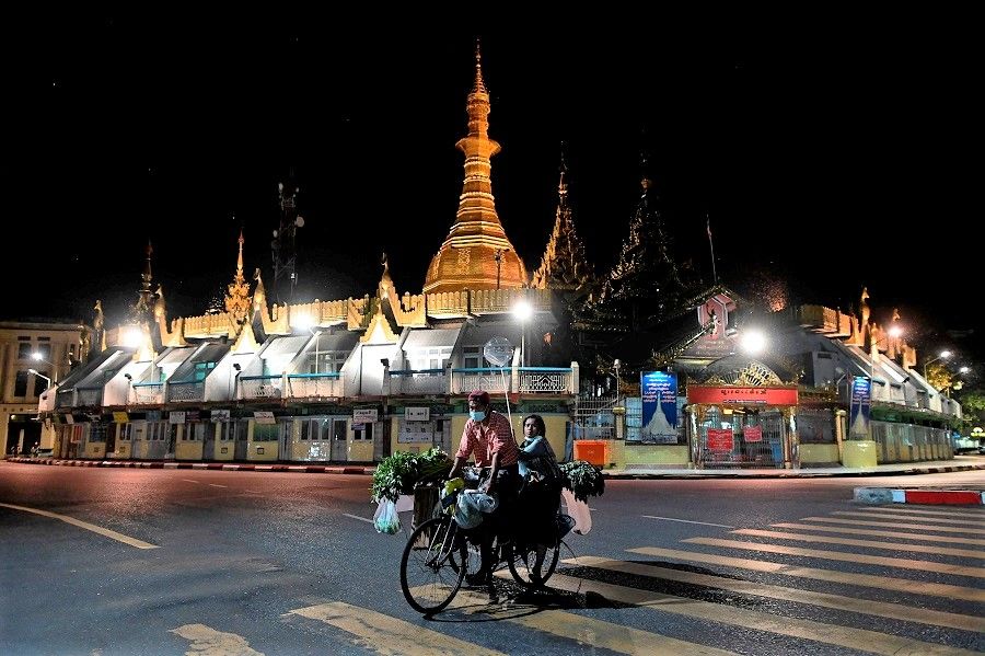 Street vendors ride past the Sule Pagoda in Yangon, Myanmar, on 10 November 2020. (Ye Aung Thu/AFP)