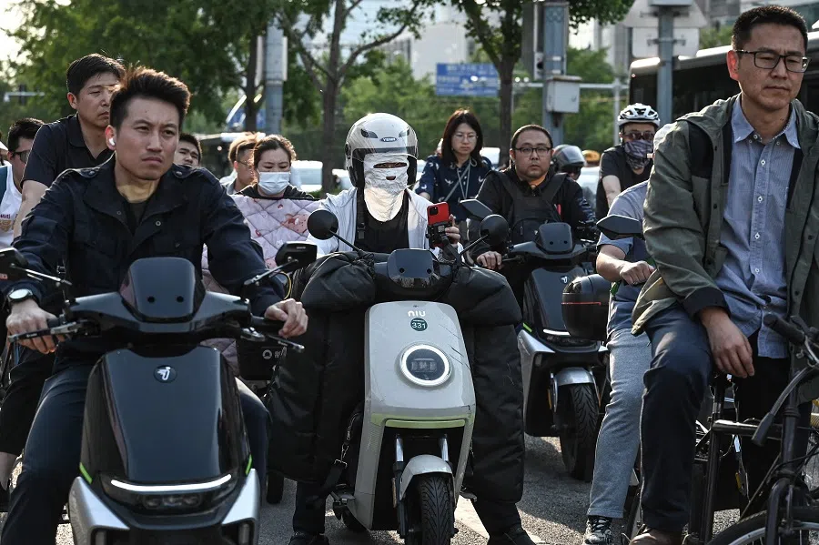 People commute on a street in Beijing on 27 May 2024.  (Jade Gao/AFP)
