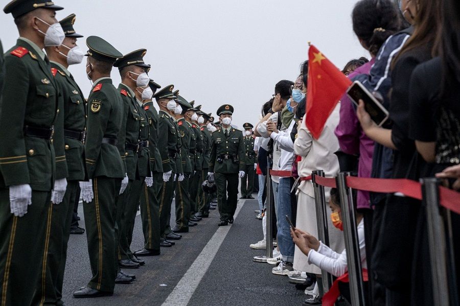 People's Liberation Army soldiers stand along a road at the end of the flag raising ceremony during National Day in Beijing, China, on 1 October 2022. (Bloomberg)