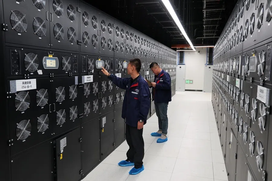 The photograph shows staff inspecting and maintaining equipment inside an intelligent computing centre at the Horinger data centre cluster in Inner Mongolia, 11 September 2026.