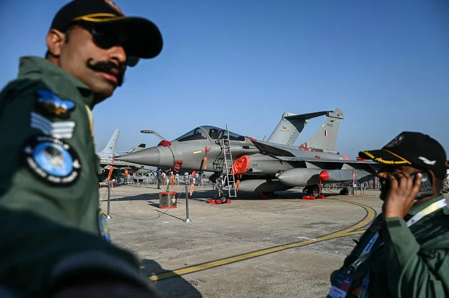 Indian Air Force (IAF) personnel stand in front of the Rafale fighter jet during Aero India 2025, a military aviation exhibition at the Yelahanka Air Force Station in Bengaluru on 13 February 2025.