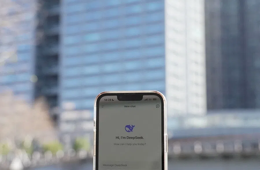 This photo illustration shows the DeepSeek app on a mobile phone in front of the building housing the headquarters of Chinese AI startup DeepSeek in Hangzhou, Zhejiang province, China, on 28 January 2025.