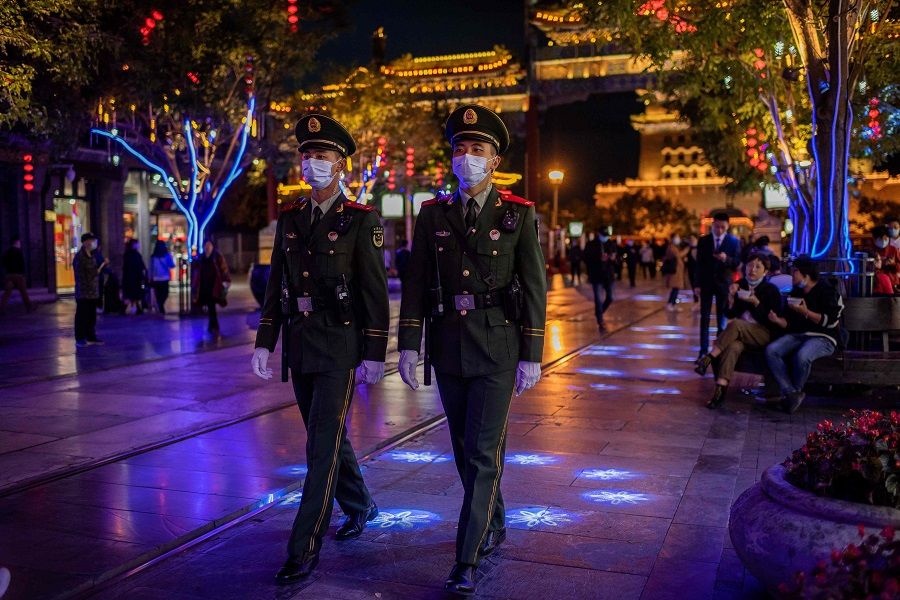 Paramilitary police officers wearing face masks patrol on a street in Beijing on 13 October 2020. (Nicolas Asfouri/AFP)