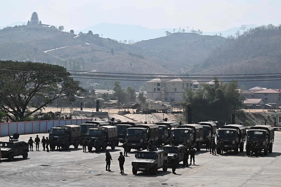 Kyauk Khet in Myanmar’s Kayin state is seen in the background as Thai Army trucks park on the Thai side of the border crossing in Chong Kaep town as they wait for the arrival of alleged victims from scam centres in Myanmar, in Phop Phra district in Thailand’s Tak province on 12 February 2025. (Lillian Suwanrumpha/AFP)