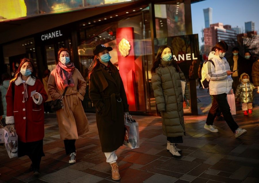 People walk past a Chanel store in a shopping district during Lunar New Year holidays following an outbreak of the coronavirus disease (COVID-19) in Beijing, China, 16 February 2021. (Thomas Peter/Reuters)