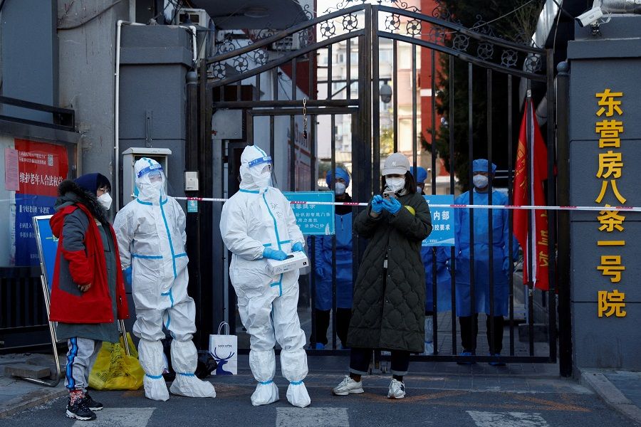 Security personnel in protective suits stand at the gate of a residential compound that is under lockdown as Covid-19 outbreaks continue in Beijing, China, 22 October 2022. (Thomas Peter/File Photo/Reuters)
