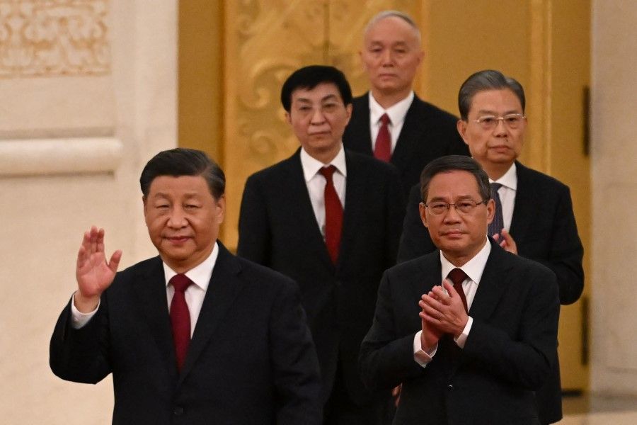 This file photo taken on 23 October 2022 shows China's President Xi Jinping (left) walking with members of the Chinese Communist Party's new Politburo Standing Committee as they meet the media in the Great Hall of the People in Beijing. (Noel Celis/AFP)