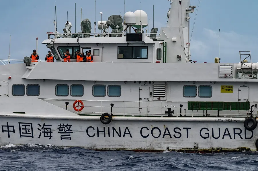 Personnel on board a China Coast Guard ship are seen from the Philippine Coast Guard vessel BRP Cabra during a supply mission to Sabina Shoal in disputed waters of the South China Sea on 26 August 2024.