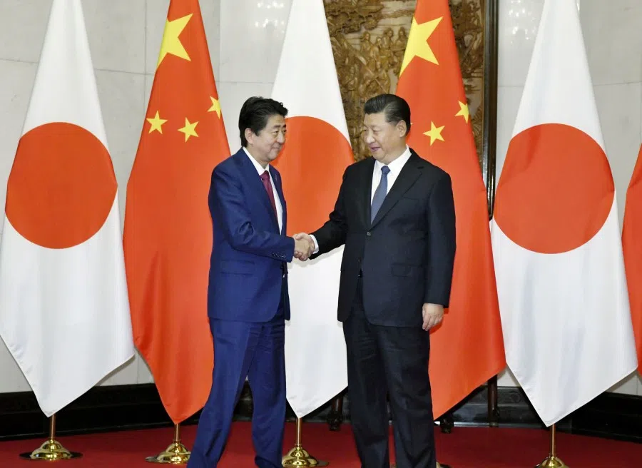Former Japanese president Shinzo Abe (left) shakes hands with China's President Xi Jinping during a meeting in Beijing, China in this photo taken by Kyodo, 26 October 2018. (Kyodo via Reuters)