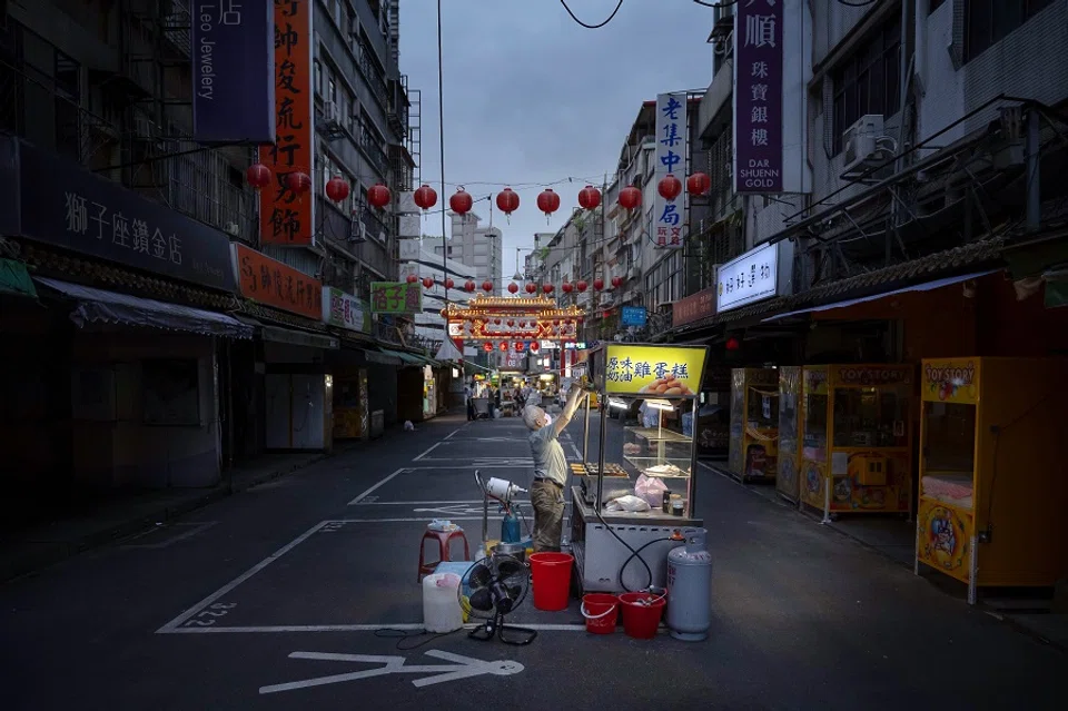 A vendor wears a protective mask while working at a food stall at a market in Taipei, Taiwan, on 21 May 2021. (Billy H.C. Kwok/Bloomberg)