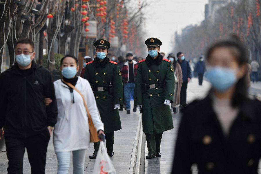Two paramilitary police officers patrol in the area south of the Great Hall of the People during the second plenary session of the National People's Congress in Beijing on 8 March 2021. (Greg Baker/AFP)