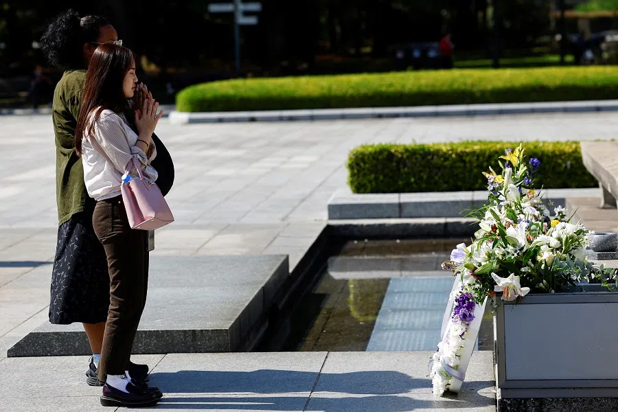 Visitors pray in front of the Cenotaph for the victims of the 1945 atomic bombing at the Hiroshima Peace Memorial Park, on the following day of The Japan Confederation of A- and H-Bomb Sufferers Organizations (Nihon Hidankyo) winning the 2024 Nobel Peace Prize, in Hiroshima, western Japan, on 12 October 2024. (Kim Kyung-hoon/Reuters)