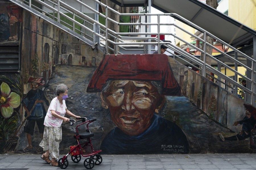 A woman walks past a mural depicting Samsui women in Chinatown, Singapore. (Edwin Koo/Bloomberg)