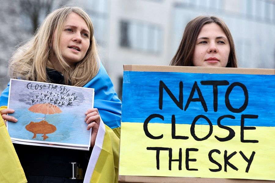 Anti-war protesters hold placards during a demonstration against Russia's invasion of Ukraine in front of the NATO headquarters in Brussels, Belgium on 16 March 2022. (Kenzo Tribouillard/AFP)