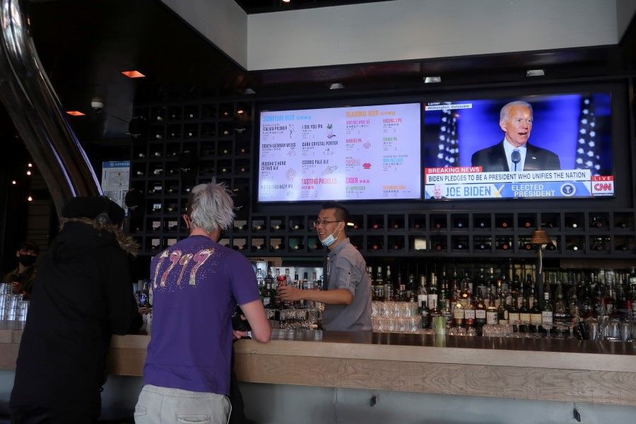 A screen shows Democratic 2020 U.S. presidential nominee Joe Biden delivering a speech after news media announced that he has won the 2020 U.S. presidential election, at a bar in Beijing, 8 November 2020. (Thomas Peter/REUTERS)