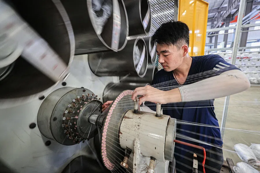 An employee works on a production line of tubular products for export at a factory in Lianyungang, in eastern China’s Jiangsu province on 8 July 2025.
