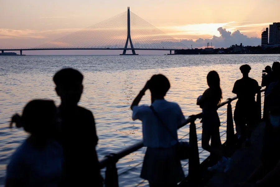 People watch the sunset near Danjiang Bridge in New Taipei City, Taiwan, on 9 July 2026.