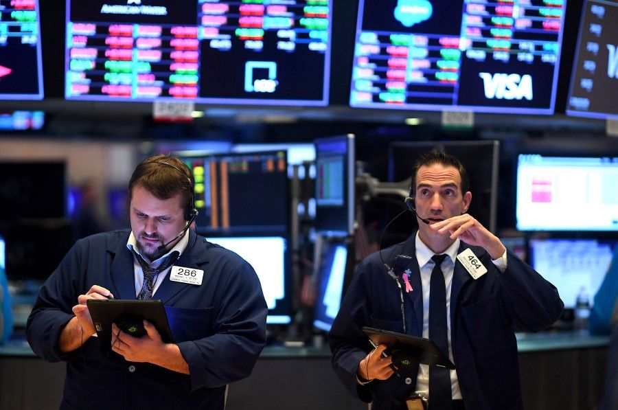 Traders work during the opening bell at the New York Stock Exchange (NYSE), March 19, 2020. (Johannes Eisele/AFP)