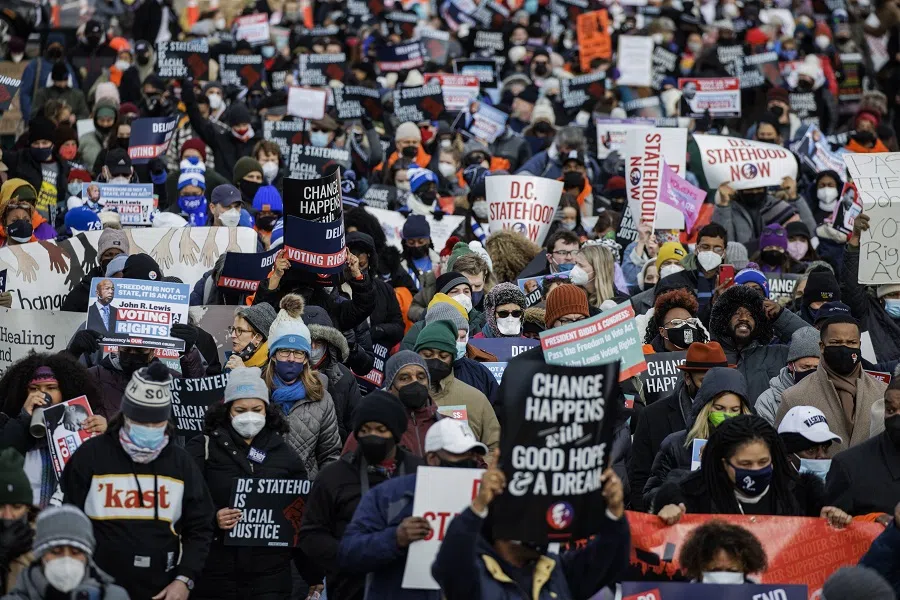 People walk across the Frederick Douglass Memorial Bridge during the annual D.C. Peace Walk: Change Happens with Good Hope and a Dream on Dr. Martin Luther King Day on 17 January 2022 in Washington, DC, US. (Samuel Corum/Getty Images/AFP)
