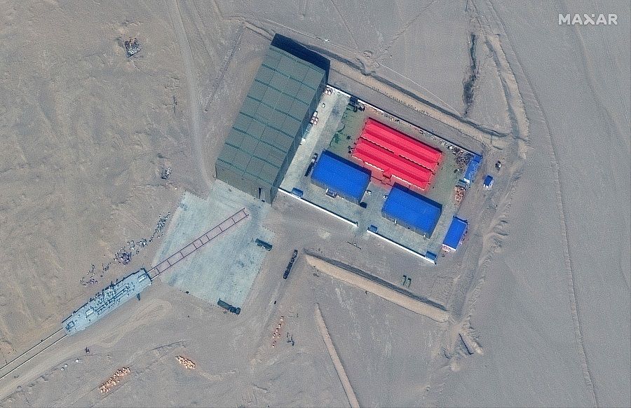 This handout satellite image released by Maxar Technologies on 8 November 2021 shows a rail terminus and a target storage building in Ruoqiang county in the Taklamakan Desert, Xinjiang, China, on 8 October 2021. (Handout/Satellite image ©2021 Maxar Technologies/AFP)