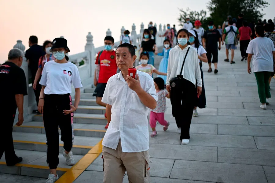 An elderly man listens to the radio while he walks at a park in Beijing on 22 August 2020. (Wang Zhao/AFP)