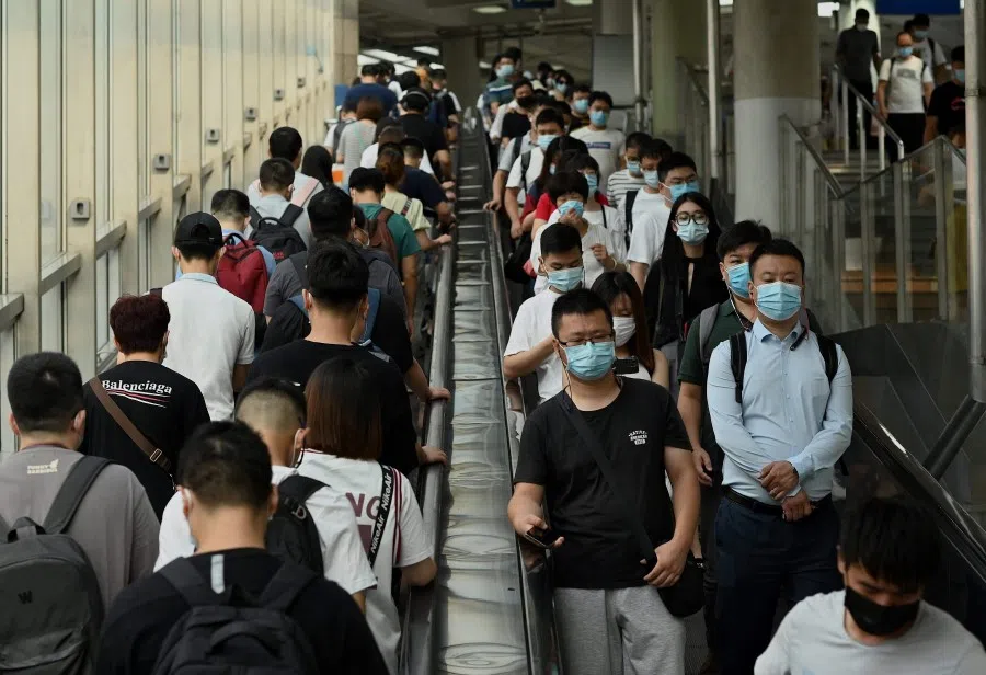 People ride escalators in and out of the subway in Beijing on 9 August 2021. (Noel Celis/AFP)