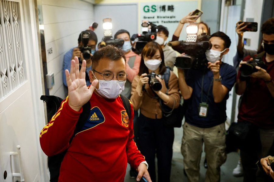Ronson Chan, Stand News deputy assignment editor, waves to the media as he leaves the Stand News office, in Hong Kong, China, 29 December 2021. (Tyrone Siu/Reuters)