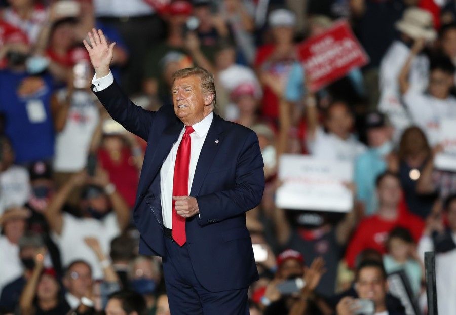 President Donald Trump waves to the crowd as he leaves after speaking during a campaign event at the Orlando Sanford International Airport on 12 October 2020 in Sanford, Florida. (Joe Raedle/AFP)