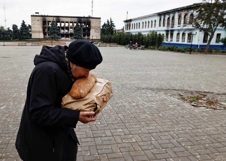 A local resident kisses bread after she received humanitarian aid, as Russia's attack on Ukraine continues, in the recently liberated town of Izium, in Kharkiv region, Ukraine, 27 September 2022. (Zohra Bensemra/Reuters)
