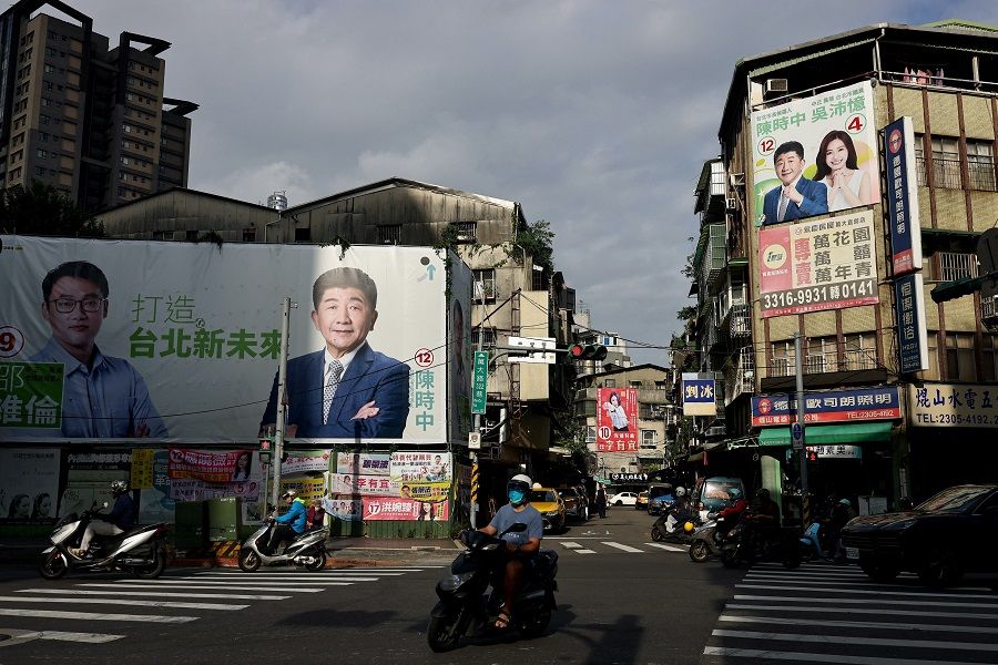 Traffic can be seen with the backdrop of election campaign posters put up in Taipei, Taiwan, 14 November 2022. (Ann Wang/Reuters)