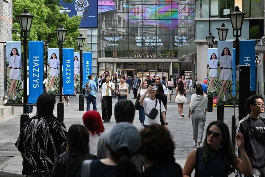 People walk on a street with luxury brand shops and a shopping mall in Shanghai, on 19 May 2026.