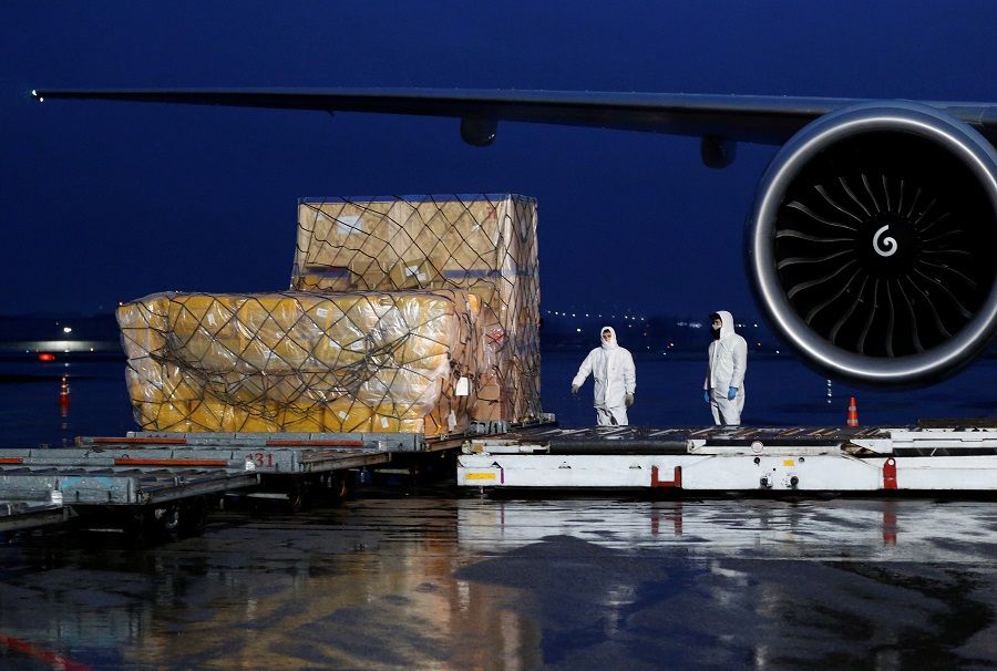 Workers unload a shipment of medical and protective gear from China to help fight the coronavirus, at Almaty International Airport, Kazakhstan, on 2 April 2020. (Pavel Mikheyev/Reuters)